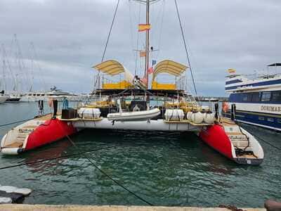 Catamarán con cascos rojos amarrado en el puerto en un día nublado