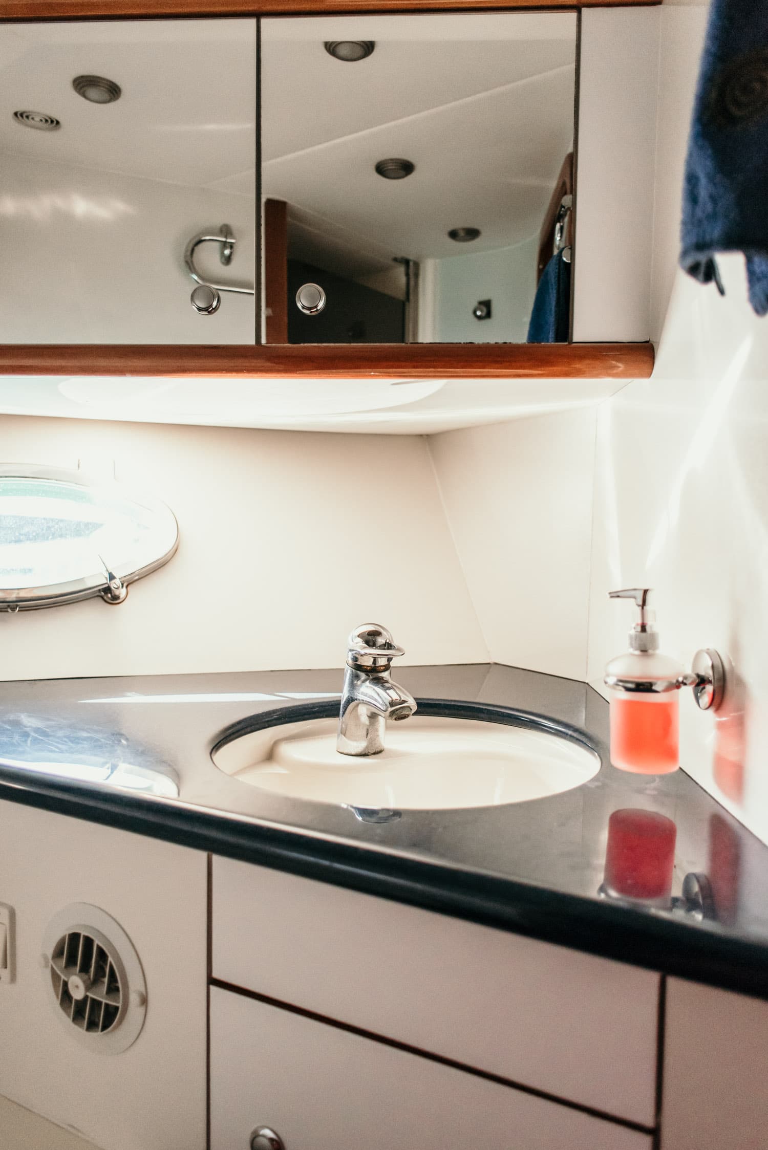 Baño privado del yate con lavabo, espejo y ojo de buey