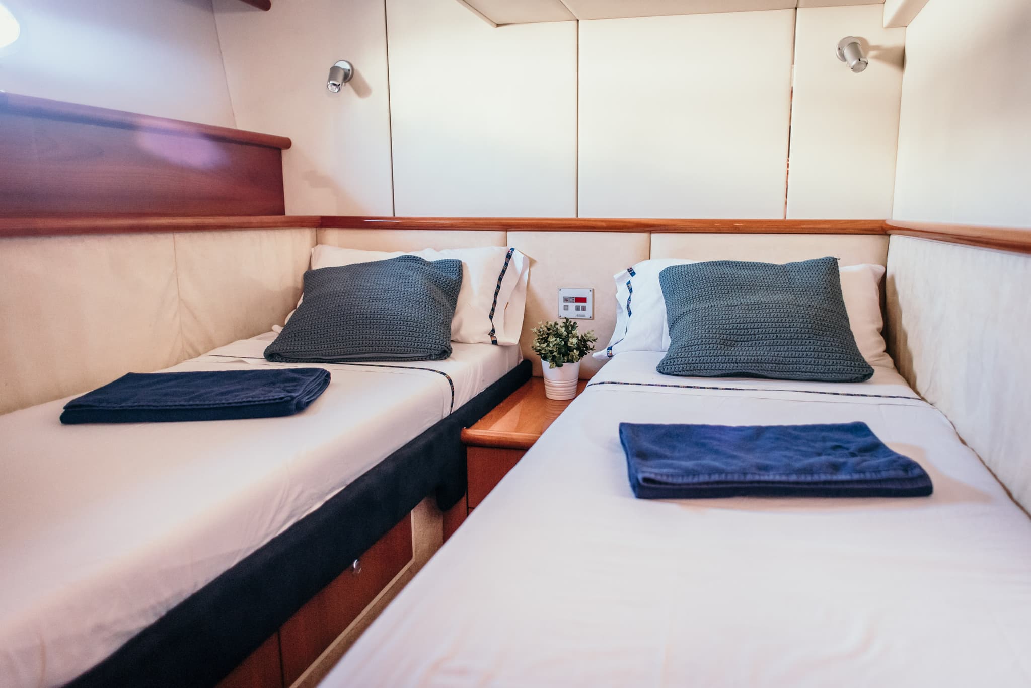 Camarote de literas del yate con ropa de cama blanca y toallas dobladas