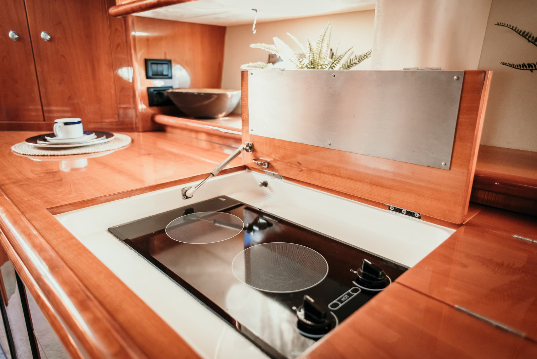 Cocina del yate con muebles de madera y placa de inducción empotrada