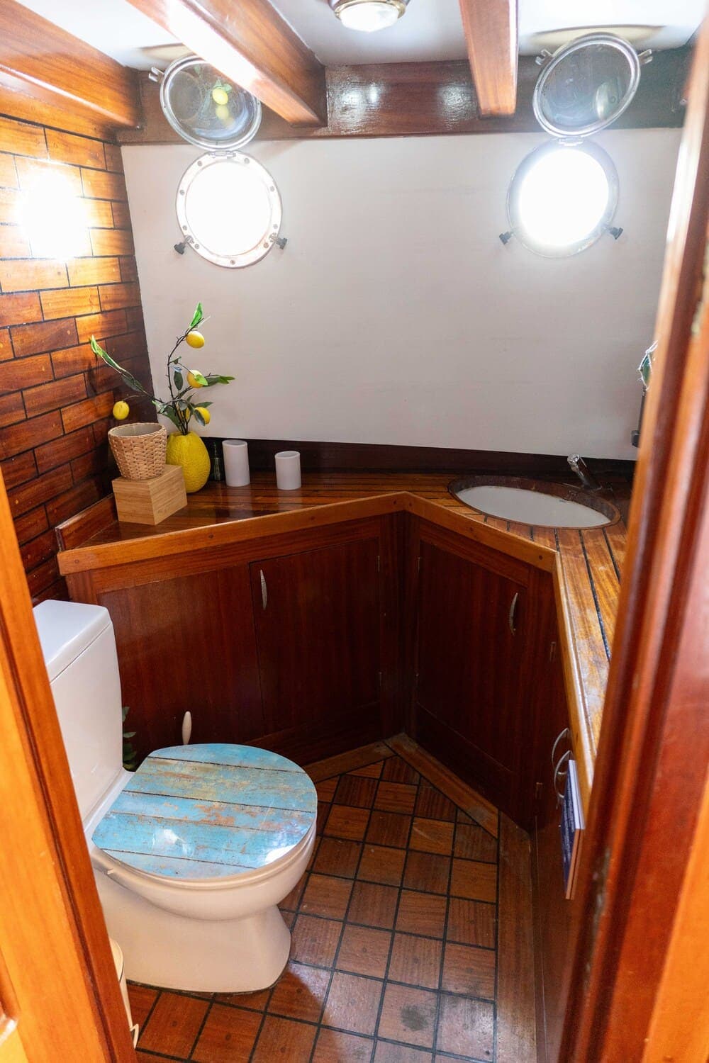 Aseo de madera a bordo de un velero con ojos de buey iluminados y lavabo empotrado