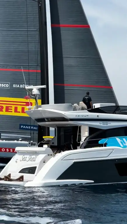 Yate a motor Azimut Sea Shell navegando junto a un velero de regata de la Copa América