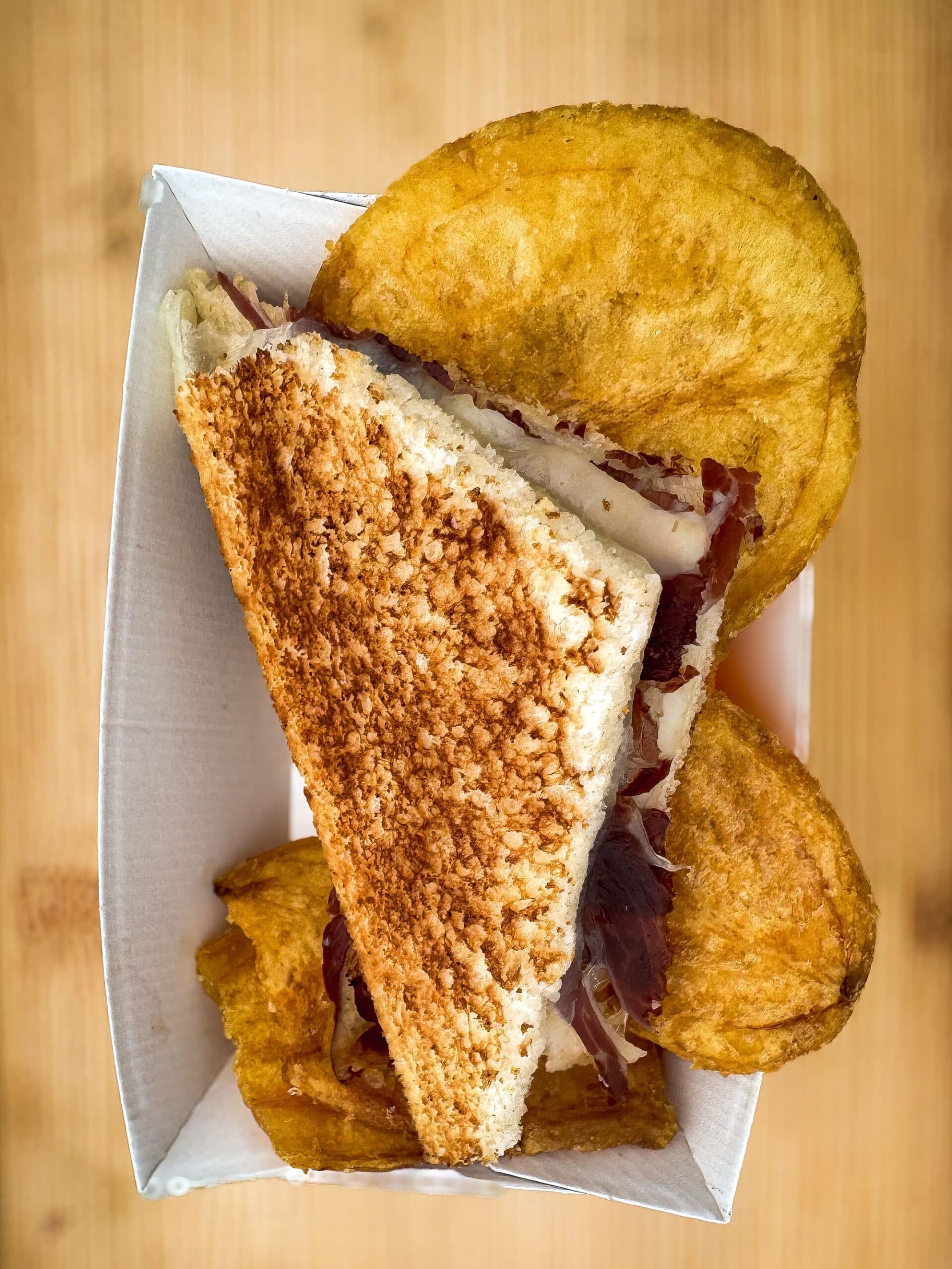 Primer plano cenital del bocadillo de jamón tostado servido en bandeja de cartón