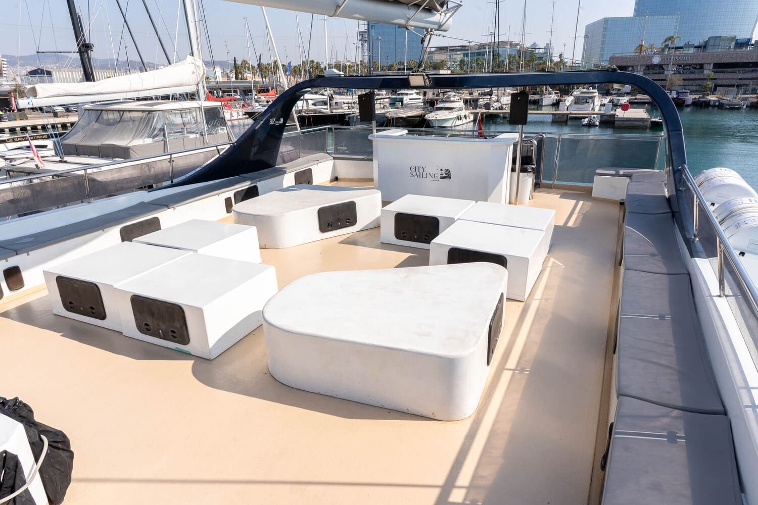 Zona de asientos cúbicos blancos en la cubierta de un catamarán amarrado en el puerto