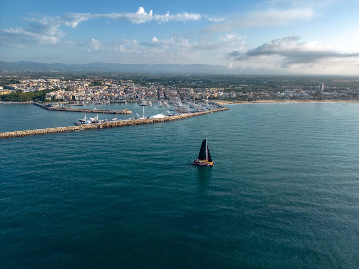 Vista aérea del catamarán frente al puerto de Cambrils con luz cálida de atardecer