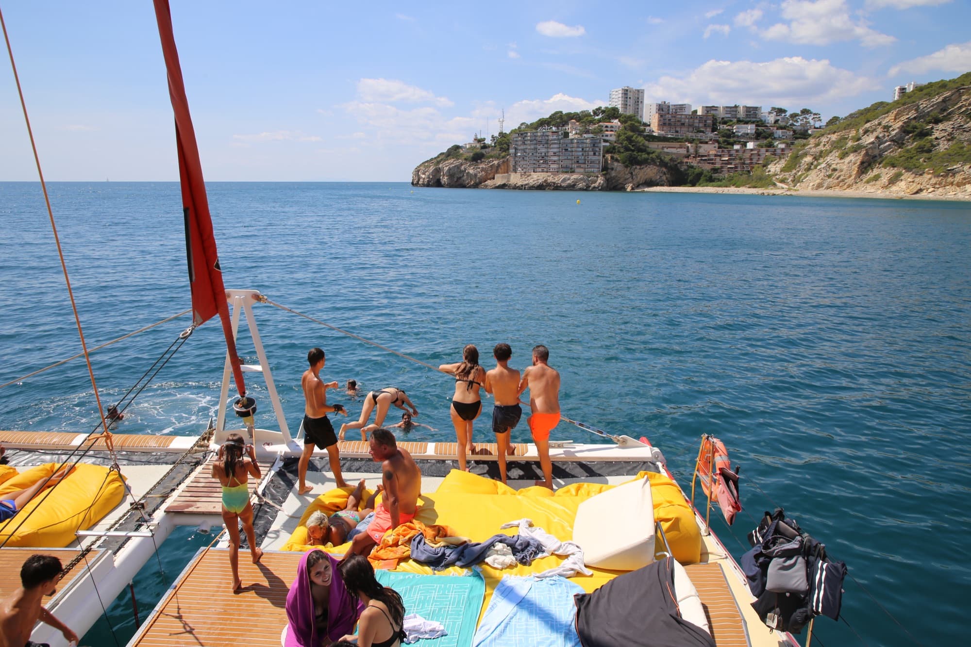 Grupo reunido junto al mástil charlando y disfrutando del sol tras el baño