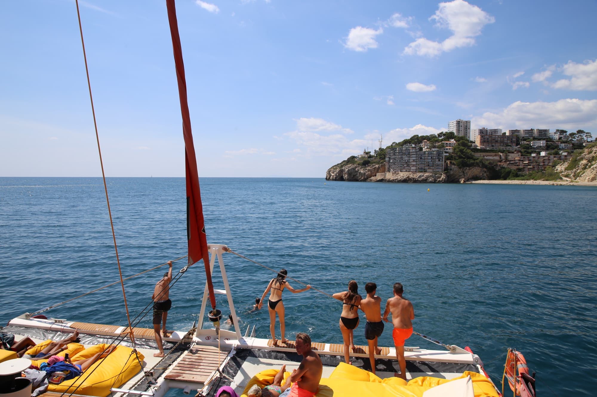 Pasajeros preparados para saltar al mar desde la proa junto a la costa de Cambrils